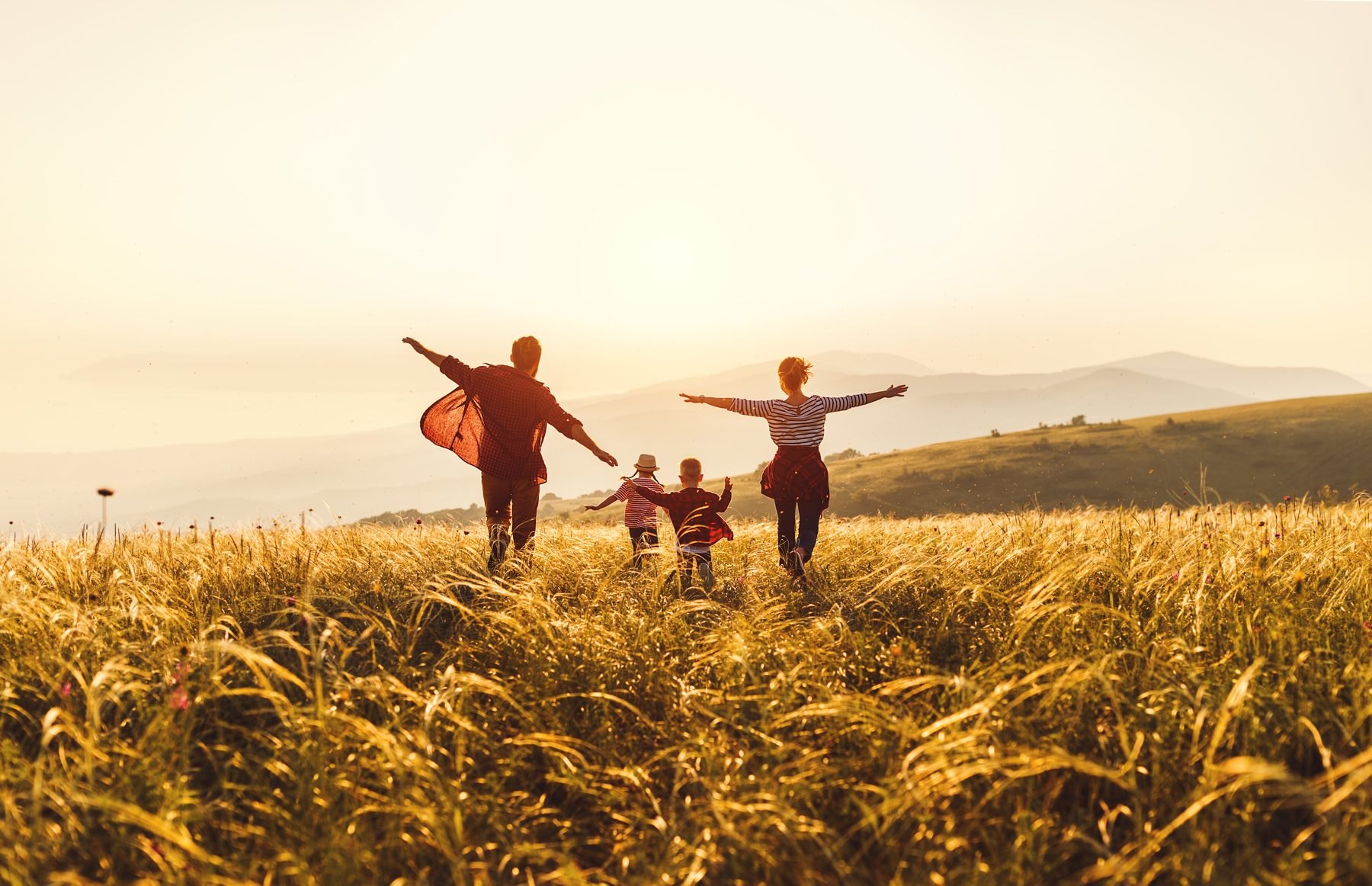 Familia corriendo en un campo al atardecer